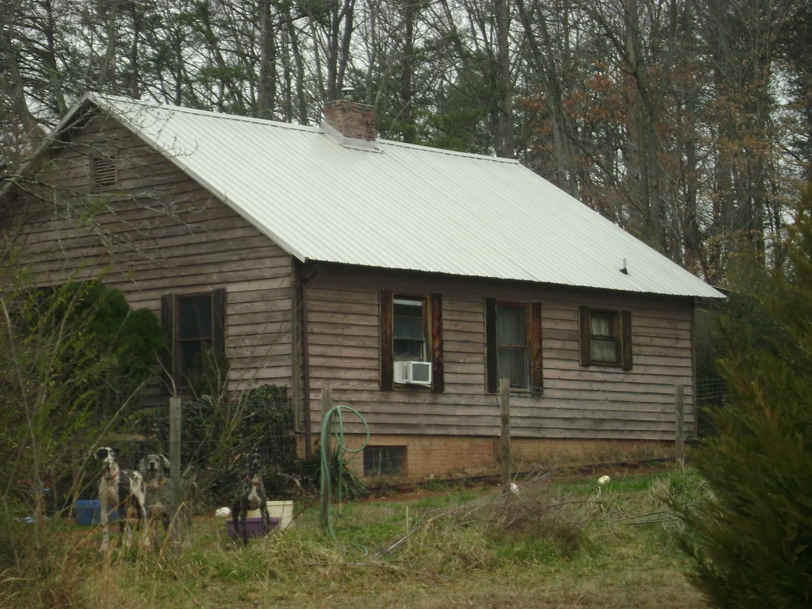 White metal roof on an old wood sided farmhouse, from a Metal Roof Installation job in Helenwood
